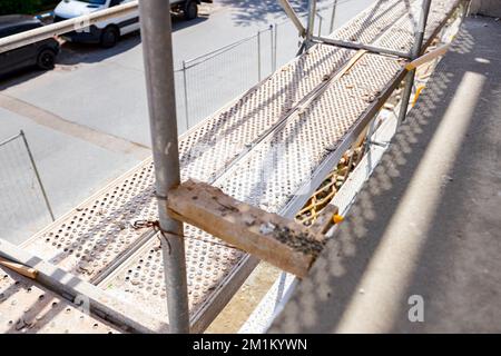 View on place for treading at metallic scaffolding that is set up for works on the unfinished residential building. Stock Photo