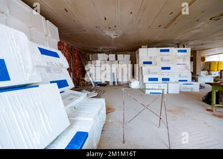 Packages of thermal insulation material, Styrofoam, wrapped in foil waiting to be installed on the walls, placed in the warehouse. Stock Photo