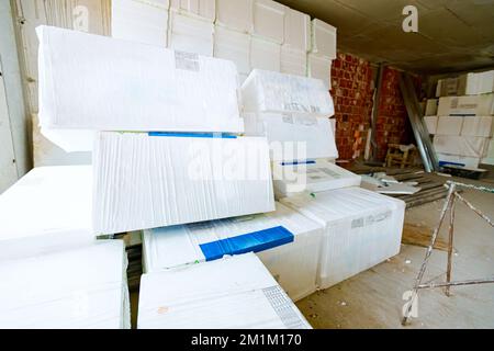 Packages of thermal insulation material, Styrofoam, wrapped in foil waiting to be installed on the walls, placed in the warehouse. Stock Photo