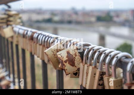 A padlock attached to a bridge railing in a spring park. Lovelock. Stock Photo