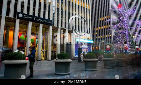 NEW YORK, NY, USA - DECEMBER 10, 2022: Beautiful Christmas tree at 6th Av near News Corporation building with blurred people walking around Stock Photo