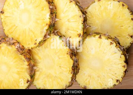 Top view of sliced pineapple on wooden background. Close up. Stock Photo