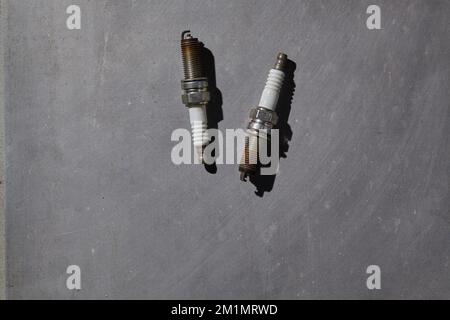 two used spark plugs that are dirty and time to replace Stock Photo