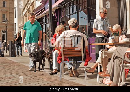 guide dog and trainer on busy pavement with obstacles Stock Photo