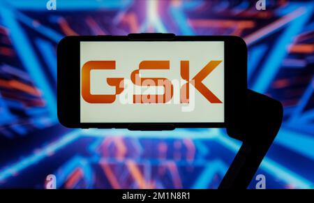 In this photo illustration, the logo of GlaxoSmithKline (GSK) is seen displayed on a mobile phone screen. Stock Photo