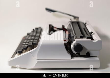 Typewriter from the 70s. Side view on a light background Stock Photo