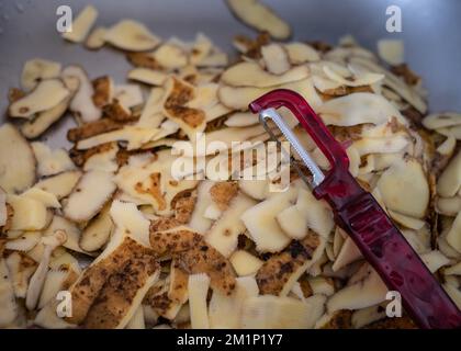 Fresh potatoes peels and a small vegetable knife. Household biodegradable waste. View from above Stock Photo