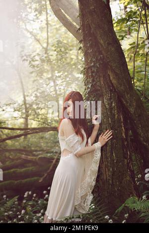 Victorian woman in misty woods Stock Photo