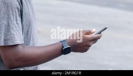 Hand of young black african man holding white blank screen smartphone Stock Photo