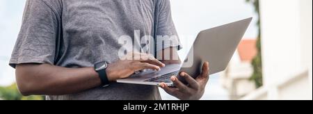 Side view, African web developer works with his laptop. Stock Photo