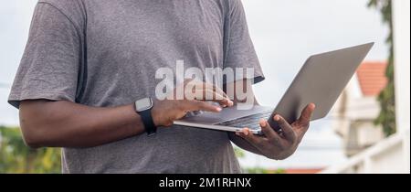 Side view, African web developer works with his laptop. Stock Photo