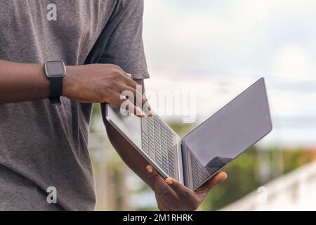 Side view, African web developer works with his laptop. Stock Photo