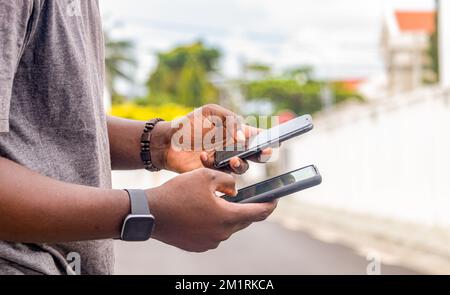 African man hands holding two smartphone with blank space screen for your texting or news content Stock Photo