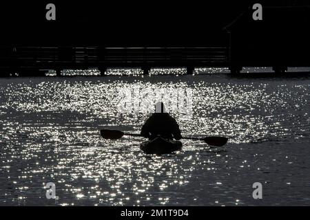 A kayak cominig out sun on the sparkling water on Loch Lomond. Stock Photo