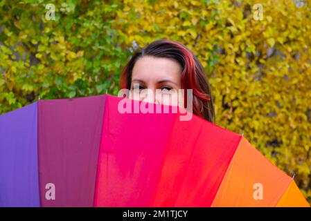the rainbow huge umbrella and girl one peeking out Stock Photo