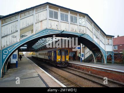 Former wooden footbridge at Beverly railway station with train to York in platform Stock Photo