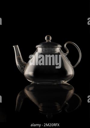 Beautiful transparent glass teapot close-up isolated on black background Stock Photo