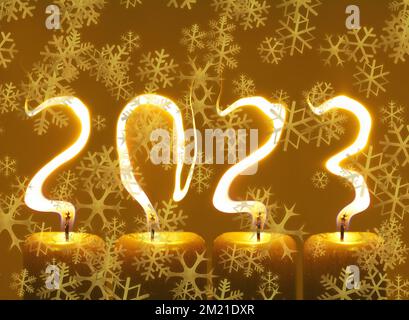 Modified photo of four candles. Flames write numbers 2023, snowflakes Stock Photo