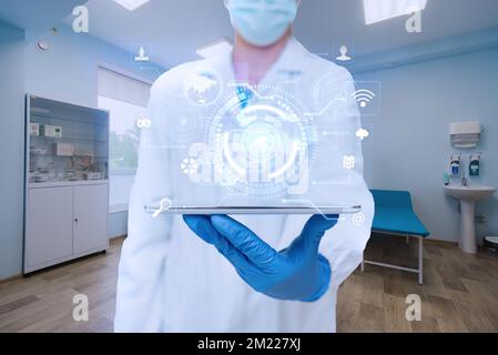 Doctor In The Laboratory Wearing Gloves Holding A Tablet Showing Futuristic Technology. Scientist Inside Workshop Using Tab Stock Photo