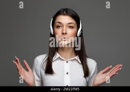 friendly smiling woman with headset is consulting clients online. Stock Photo