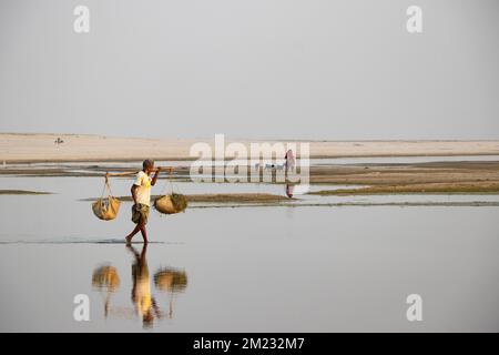 Bogura, Rajshahi, Bangladesh. 13th Dec, 2022. Passengers cross a dry riverbed on foot near Jamuna River in Bogura, Bangladesh. Most of the waterways along the Jamuna river basin in Northern Bangladesh have already dried up and created huge sandbars, disrupting plying of boats and the movement of passengers. The sandbars, known in Bengali as ''Chars'', do not occupy a permanent position. (Credit Image: © Joy Saha/ZUMA Press Wire) Stock Photo