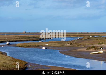 Marshes and river Glaven in Blakeney National Nature Reserve with Race Bank Wind Farm situated beyond the horizon in the Norh Sea, Norfolk, England Stock Photo
