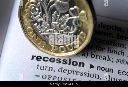 DICTIONARY DEFINITION OF WORD RECESSION WITH ONE POUND COIN RE COST OF LIVING CRISIS INFLATION MORTGAGES DOWNTURN ECONOMY ETC UK Stock Photo