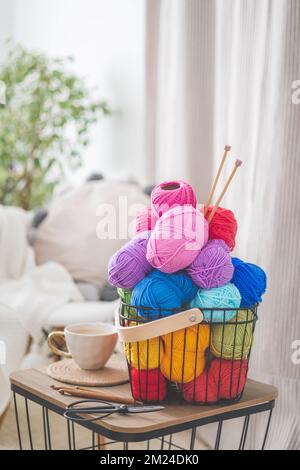 Cozy homely atmosphere. Female hobby knitting and Crochet. Yarn multicolor  in a basket. Skeins and balls. Stock Photo