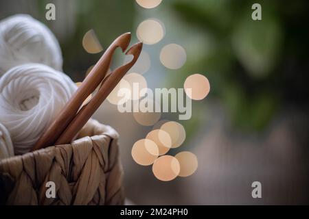 Cozy homely atmosphere. Female hobby knitting and Crochet. Yarn multicolor  in a basket. Skeins and balls. Stock Photo