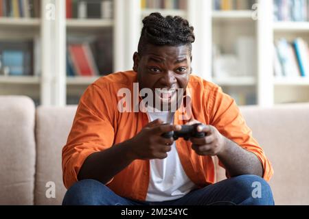 Handsome young black man playing video games at home Stock Photo