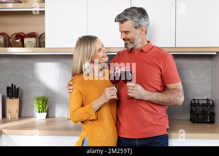 Romantic middle aged husband and wife drinking wine at home Stock Photo