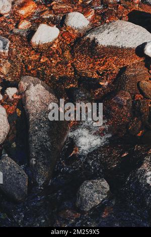 A top view of the Olterudelva River flowing through slippery rocks in Toten, Norway in late summer Stock Photo