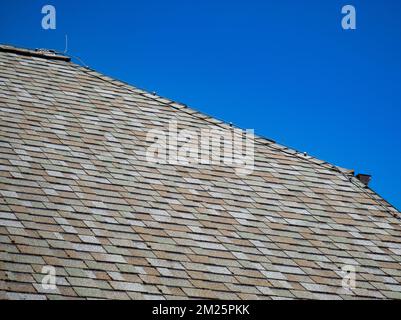 Grey clay ceramic tiled roof. Blue sky. Close-up Stock Photo