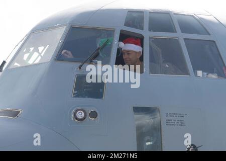 Yigo, United States. 03 December, 2022. U.S. Air Force Col. Andrew Roddan, 374th Airlift Wing commander, performs a pre-flight inspection wearing a Santa hat before taking off during Operation Christmas Drop 2022 at Andersen Air Force Base, December 3, 2022 in Yigo, Guam. Operation Christmas Drop is the oldest humanitarian and disaster relief mission delivering 71,000 pounds of food, gifts, and supplies to assist remote island communities in the South Pacific.  Credit: Yasuo Osakabe/US Airforce Photo/Alamy Live News Stock Photo