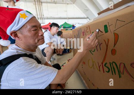Yigo, United States. 03 December, 2022. Korean Air Force Chief Master Sgt. Cho Kang Hyun decorates a bundle box in preparation for delivery during Operation Christmas Drop 2022 at Andersen Air Force Base, December 3, 2022 in Yigo, Guam. Operation Christmas Drop is the oldest humanitarian and disaster relief mission delivering 71,000 pounds of food, gifts, and supplies to assist remote island communities in the South Pacific.  Credit: Yasuo Osakabe/US Airforce Photo/Alamy Live News