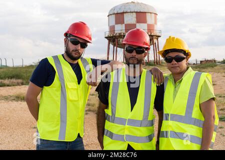 Three workers standing on the construction site Stock Photo