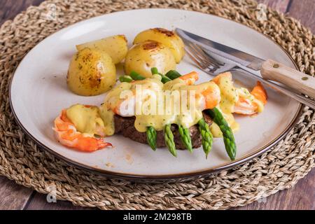 An above view of steak and asparagus with jumbo prawns and roasted potatoes. Stock Photo