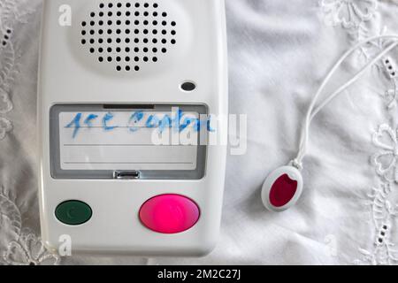 Life-saving personal alarm for the elderly and disabled people showing pendant with push button and alarm unit with loudspeaker | Unité de téléassistance et bouton de l'émetteur pour personnes agées 07/01/2018 Stock Photo