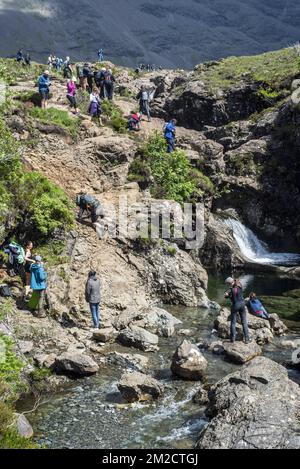 Large group of tourists visiting the Fairy Pools, succession of waterfalls in Glen Brittle on the Isle of Skye, Scottish Highlands, Scotland, UK | Promeneurs visitent Fairy Pools à Glen Brittle, île de Skye, Ecosse, Royaume-Uni 02/06/2017 Stock Photo