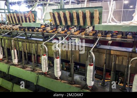 Roving frame machine for drafting the sliver into roving by twisting fibers in cotton mill / Carding machine that disentangles, cleans and intermixes fibres to produce a continuous web or sliver in cotton mill / spinning-mill | Banc à broches dans filature cotonnière 11/02/2018 Stock Photo