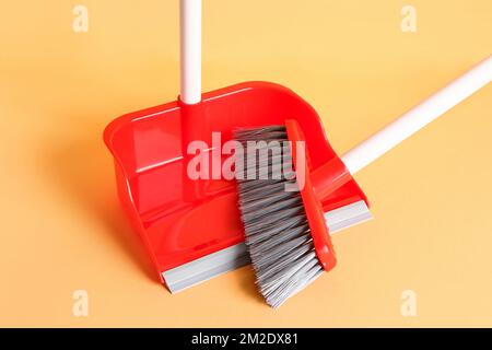 Red dustpan and broom on color background, closeup Stock Photo