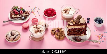 Table with various cookies, donuts, cakes, cheesecakes and coffee cups  on pink background.  Delicious dessert table. Stock Photo