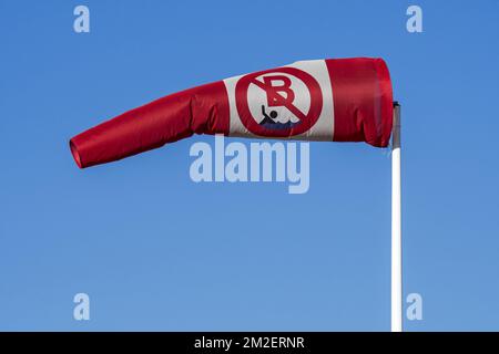 Blowing red and white windsock with no swimming / no bathing notice showing wind direction and speed | Manche à air / manche à vent 07/02/2018 Stock Photo