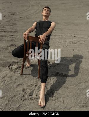 Lone Man sitting on chair in desert Stock Photo