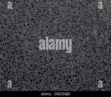 Gray terrazzo stone flooring with dark grey flecks, viewed from above. Abstract full frame textured background, top view. Stock Photo