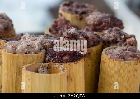 Purple sticky rice served in bamboo tubes at the Hmong New Year Celebration at El Dorado Park in  Long Beach, CA Stock Photo