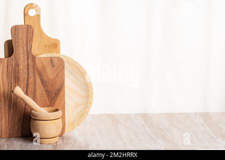 Wooden cutting boards next to a kitchen mortar, all wood. Stock Photo