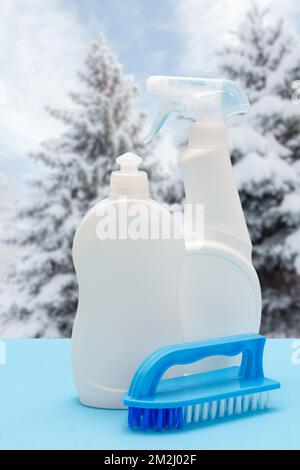 Bottles of dishwashing liquid and brush with winter on background. Stock Photo