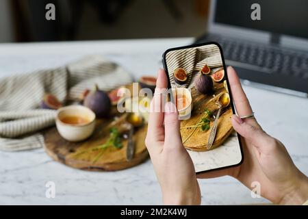 Close-up of girl taking beautiful pictures of exotic fruits on her smartphone Stock Photo