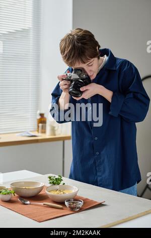 Professional photographer taking photo of food with digital camera during her work in studio Stock Photo